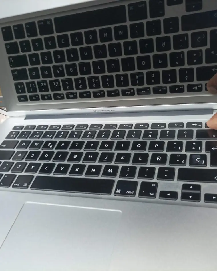 MacBook Air de varios años, abierta sobre la mesa de trabajo